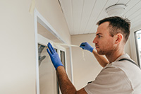 Person using silicone to seal a door
