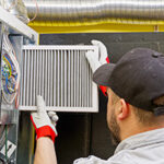 Professional performing HVAC maintenance in Ocean County by changing air filter